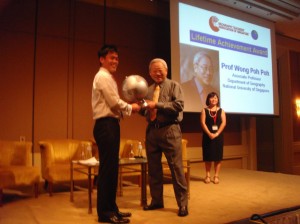 The Chairman of the Geography Teachers’ Association of Singapore, Mr Josef Tan, presents a gift to Associate Professor Wong Poh Poh during the Lifetime Achievement Award ceremony