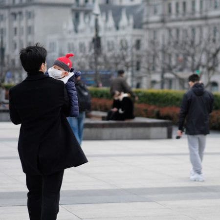 Shanghai/China-March.2020: Coronavirus 2019-nCoV pneumonia in Wuhan has been spreading into many cities. Father and baby child wearing surgical mask walking in the bund in Shanghai