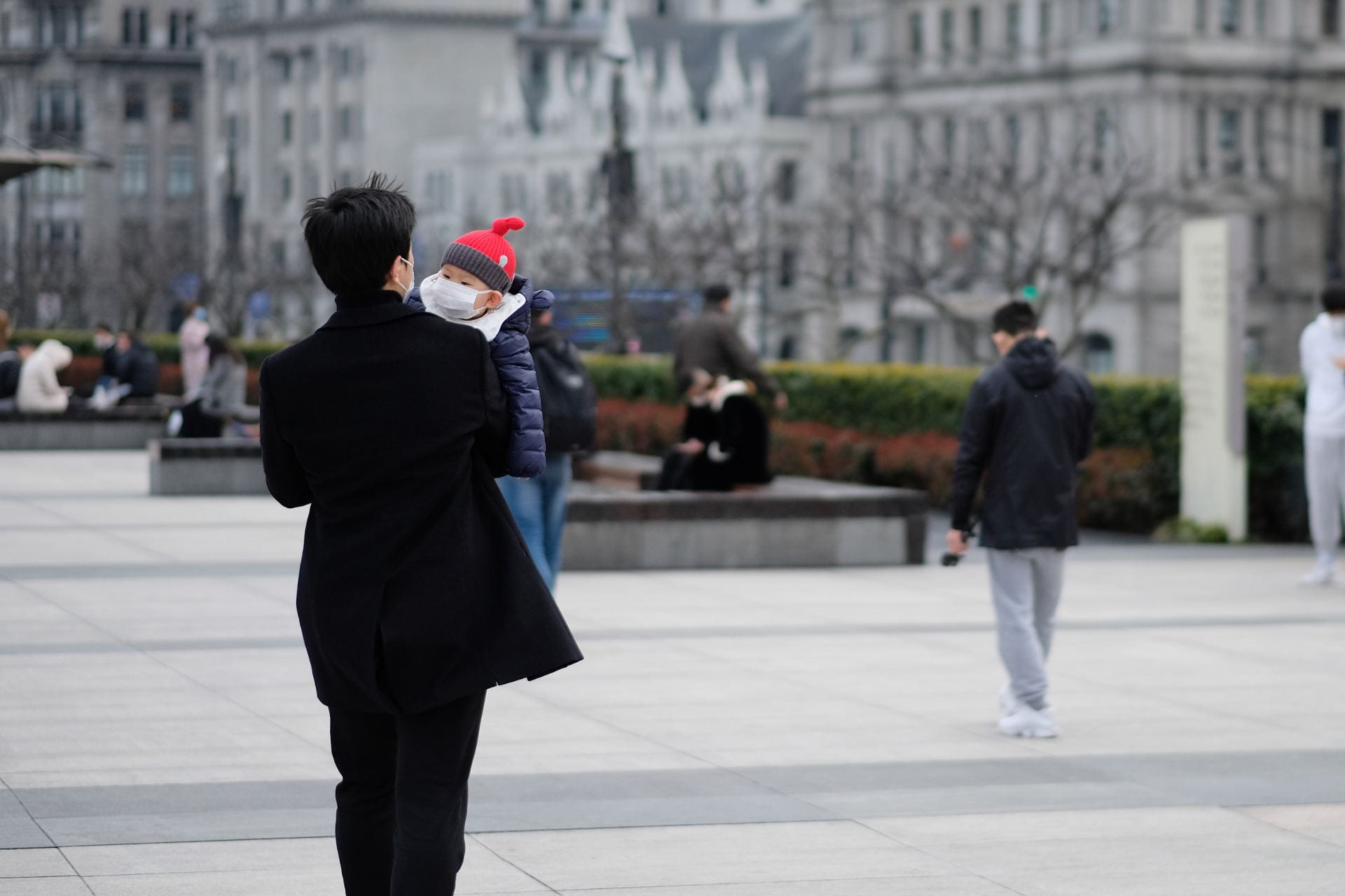 Shanghai/China-March.2020: Coronavirus 2019-nCoV pneumonia in Wuhan has been spreading into many cities. Father and baby child wearing surgical mask walking in the bund in Shanghai